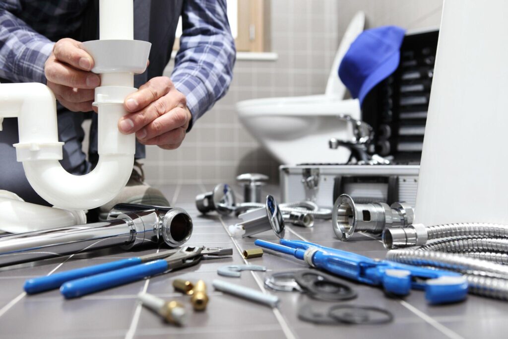 plumber at work in a bathroom, plumbing repair service