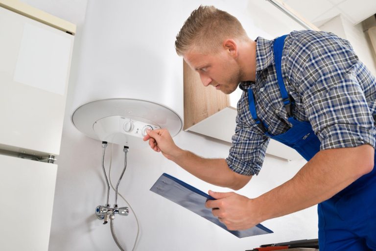 Worker with clipboard adjusting temperature of water heater
